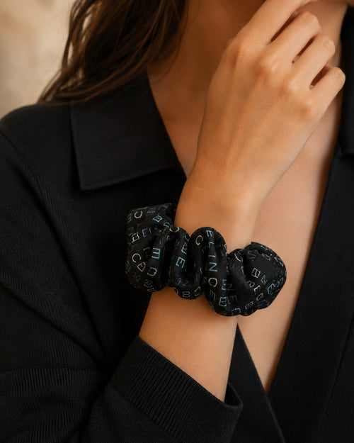 Second Soie handmade black scrunchie crafted from repurposed Celine scarf fabric with blue and ivory logo lettering.