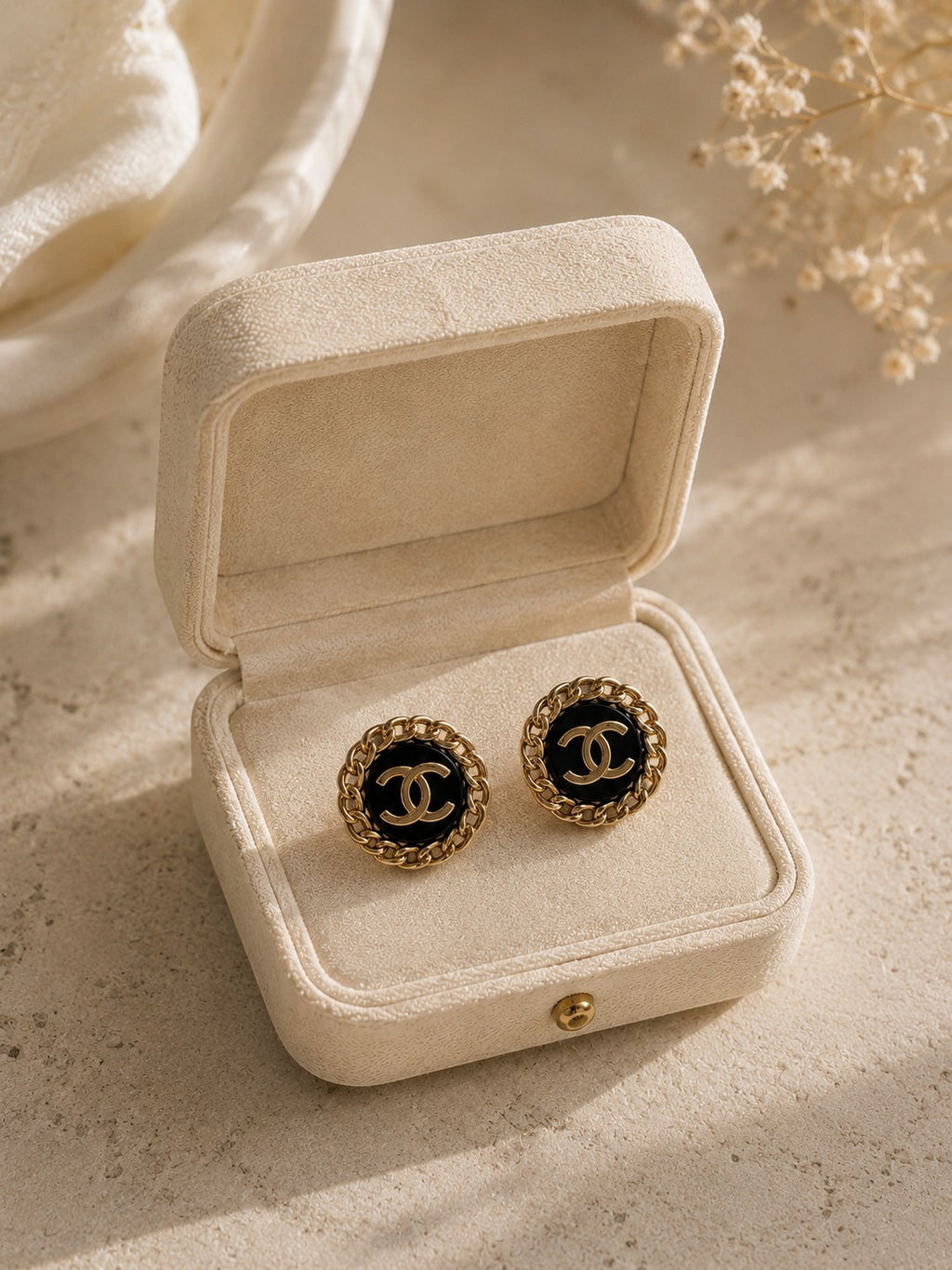 Second Soie vintage Chanel button earrings with black enamel, gold-tone CC logo, and chain border in a velvet box.