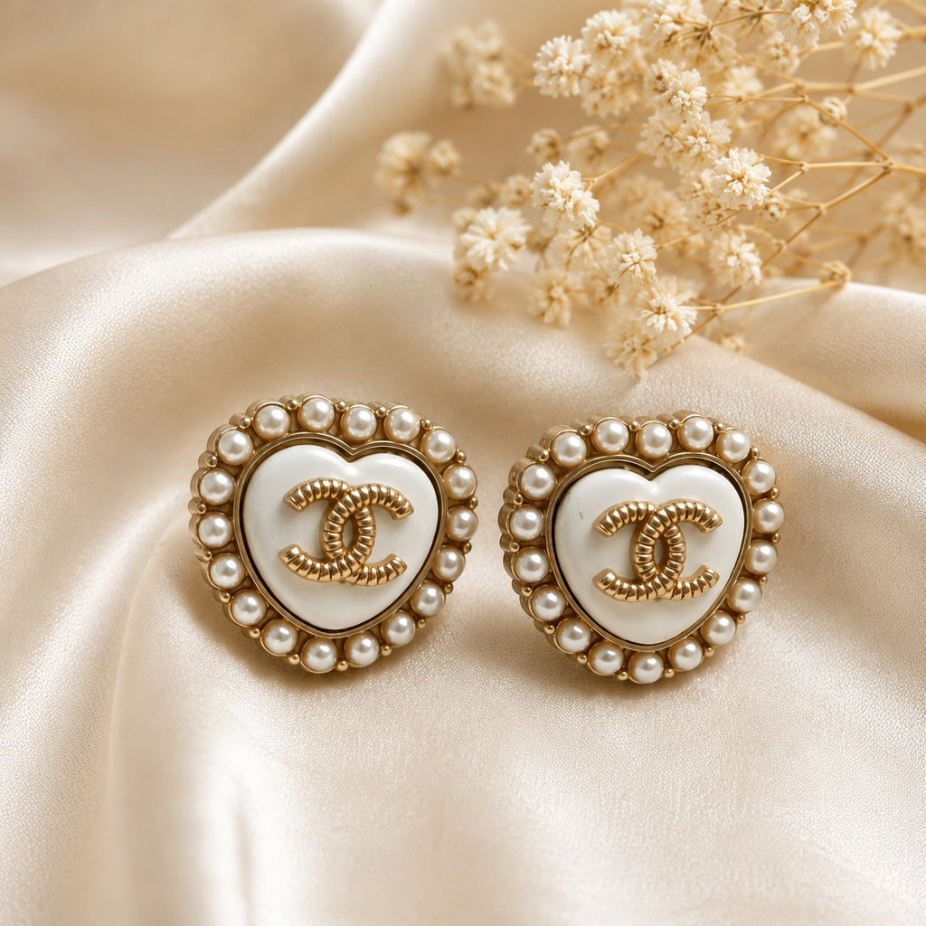 Second Soie vintage Chanel heart button earrings with ivory enamel, faux pearl halo, and gold CC logo on silk fabric.