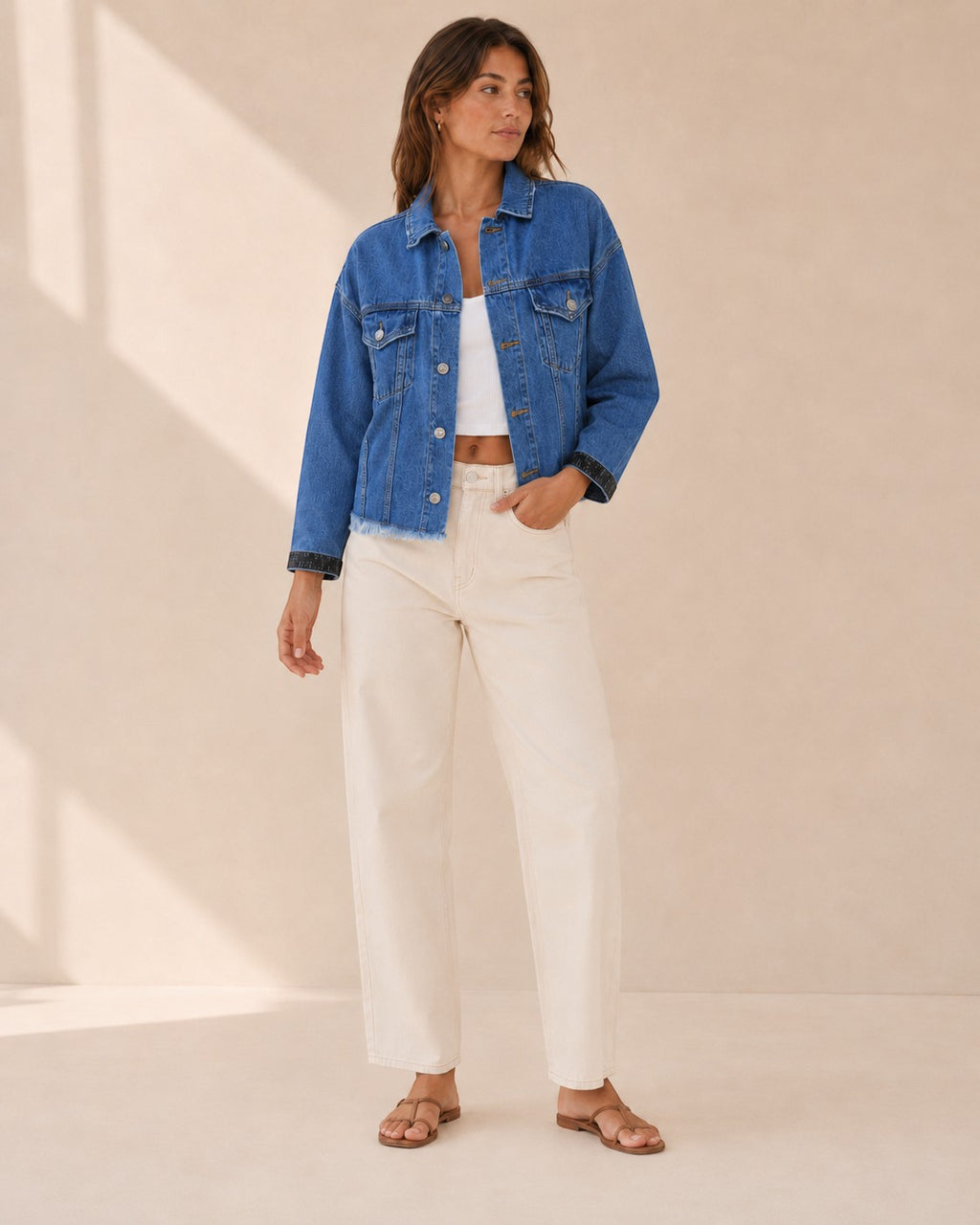 Model wearing a Second Soie cropped medium blue denim jacket with black Celine scarf cuffs and a raw frayed hem.