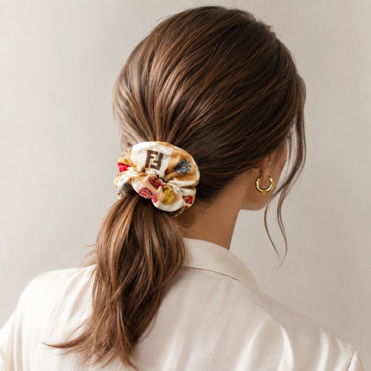 Second Soie scrunchie made from a cream and tan authentic Fendi handkerchief scarf worn in a woman's ponytail