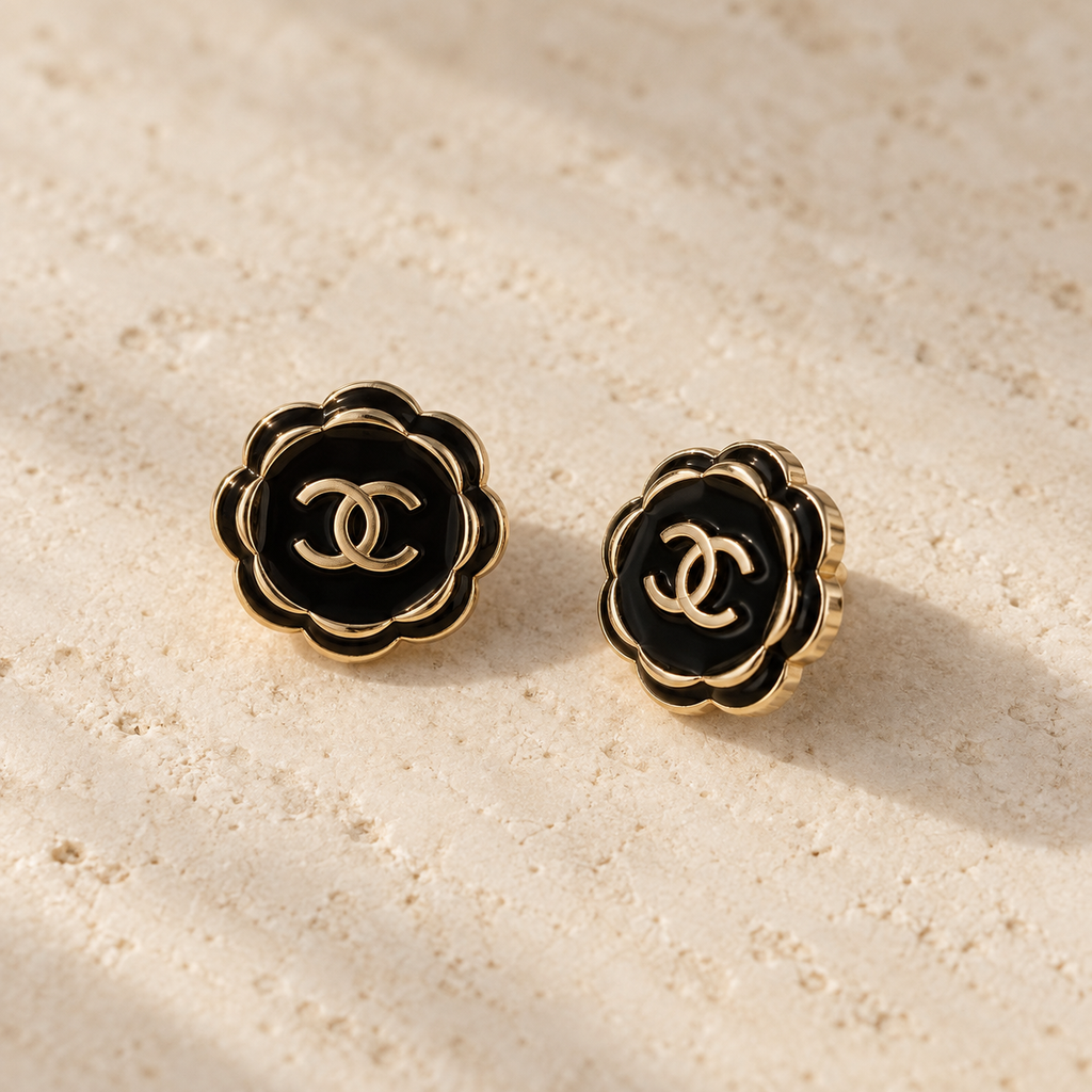 Second Soie Fleur Onyx earrings featuring black enamel floral petals with gold-tone CC logos on a textured surface.