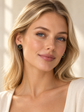 Model wearing Second Soie Fleur Onyx earrings, featuring black enamel floral petals with gold CC logo accents.