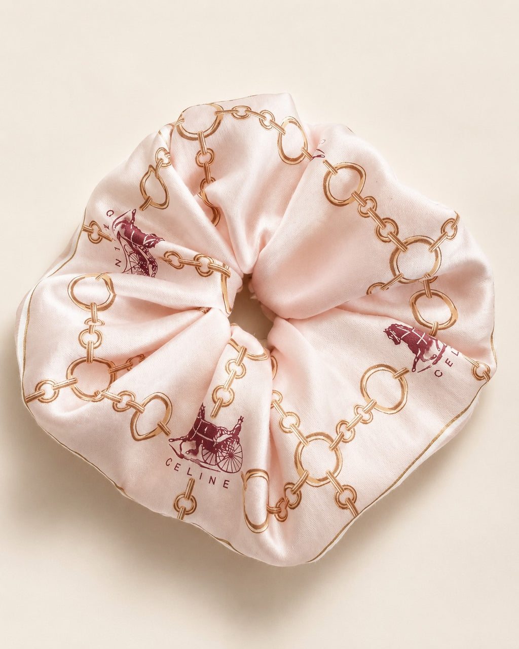 Second Soie jumbo silk scrunchie in blush pink with a Celine equestrian print featuring gold chains and horse motifs.