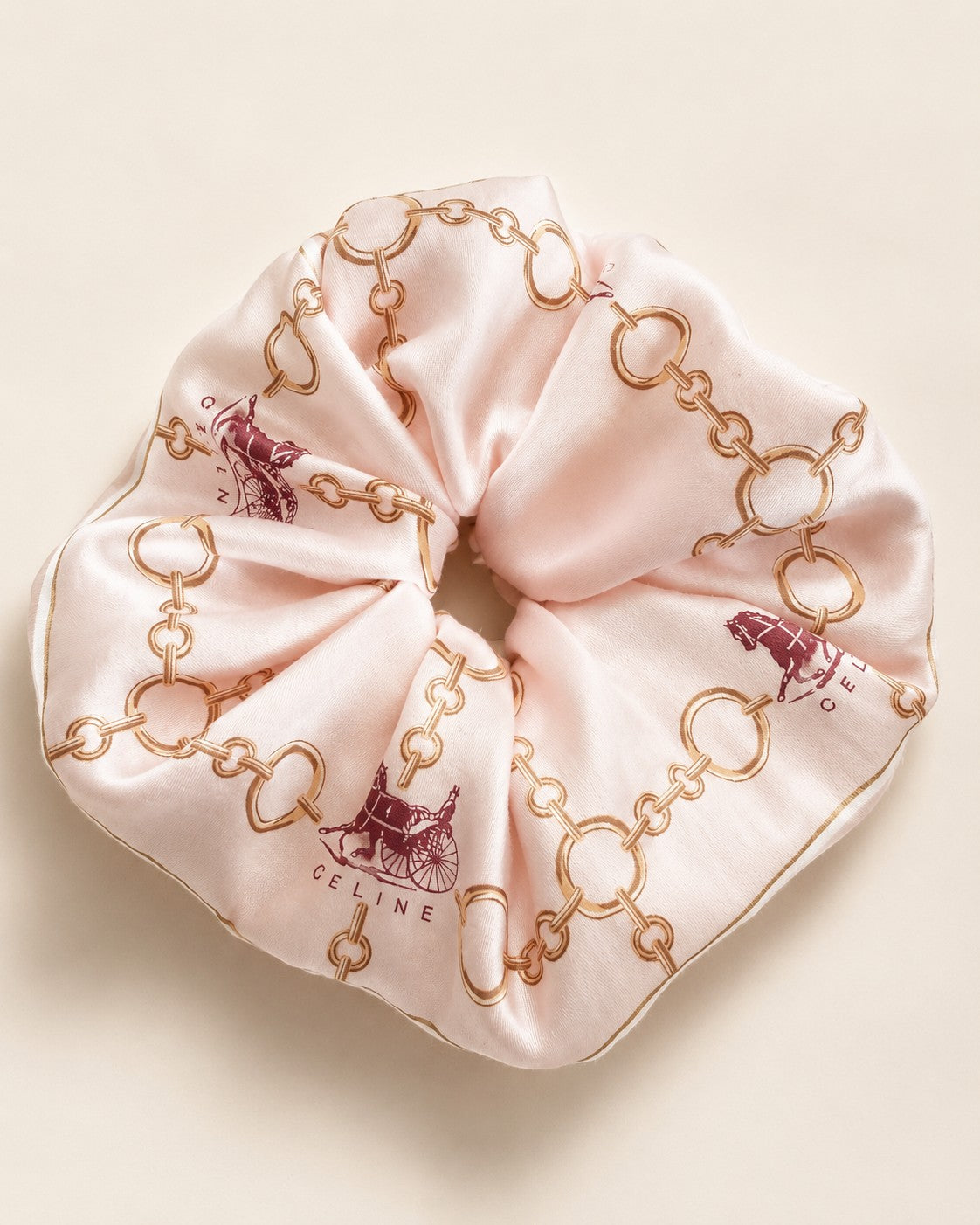 Second Soie jumbo silk scrunchie in blush pink with a Celine equestrian print featuring gold chains and horse motifs.