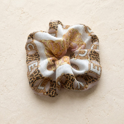 Second Soie jumbo scrunchie made from a vintage Celine cotton scarf in ivory, blush, and gold with chain print.
