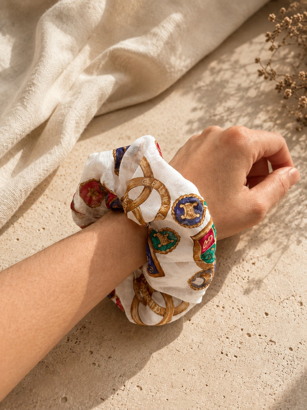 Second Soie oversized vintage Celine handkerchief scrunchie with colorful crest print worn on a wrist