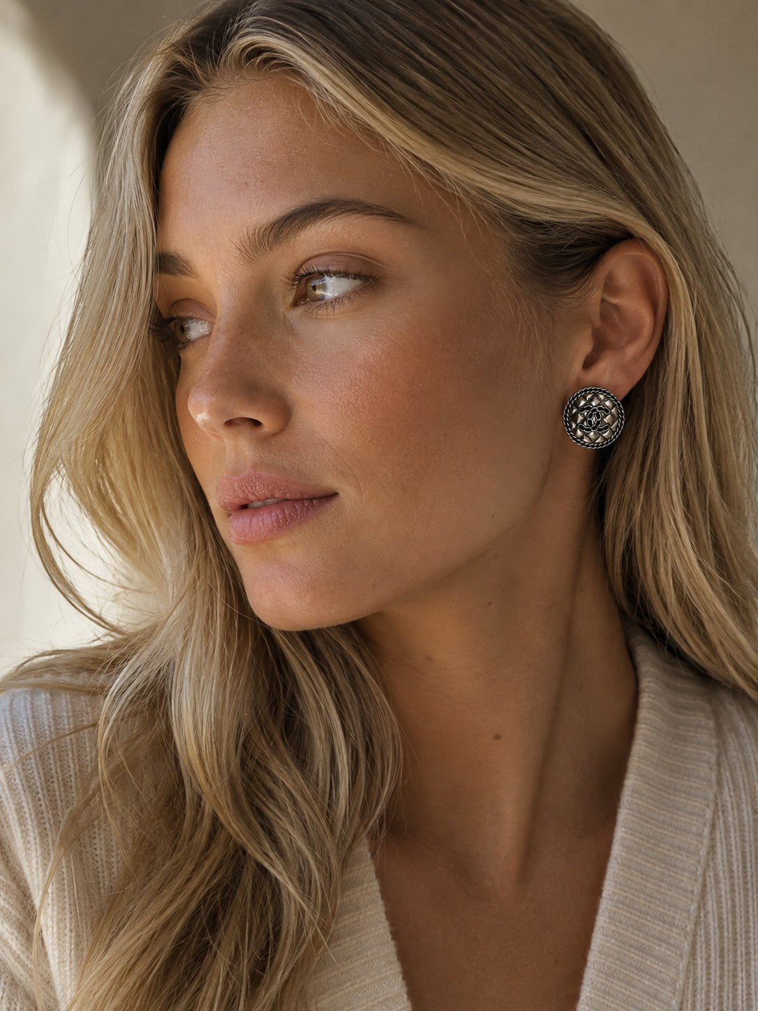 Second Soie vintage Chanel quilted silver button stud earrings worn by a blonde woman in a cream sweater