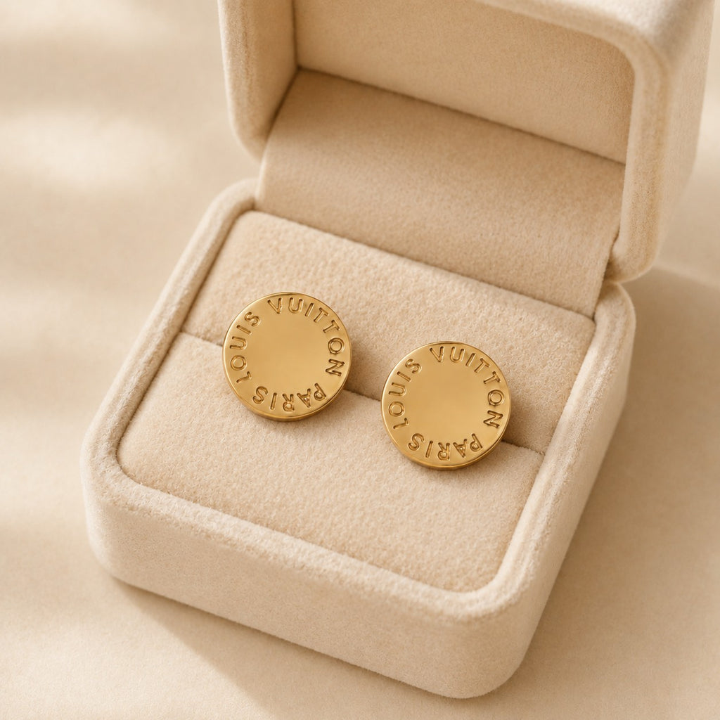 Second Soie vintage Louis Vuitton circular gold-tone stud earrings with engraved branding in a beige velvet box.