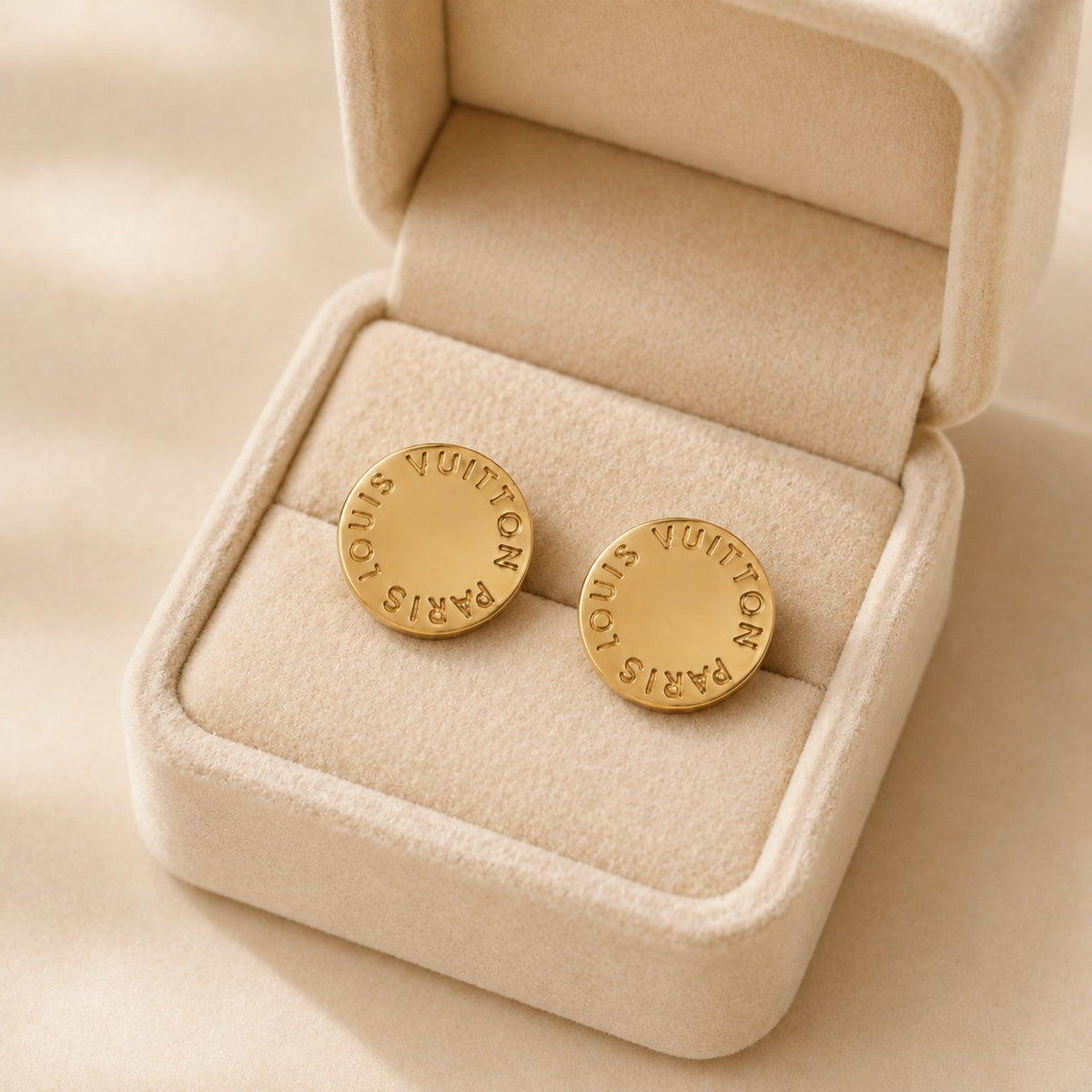 Second Soie vintage Louis Vuitton circular gold-tone stud earrings with engraved branding in a beige velvet box.