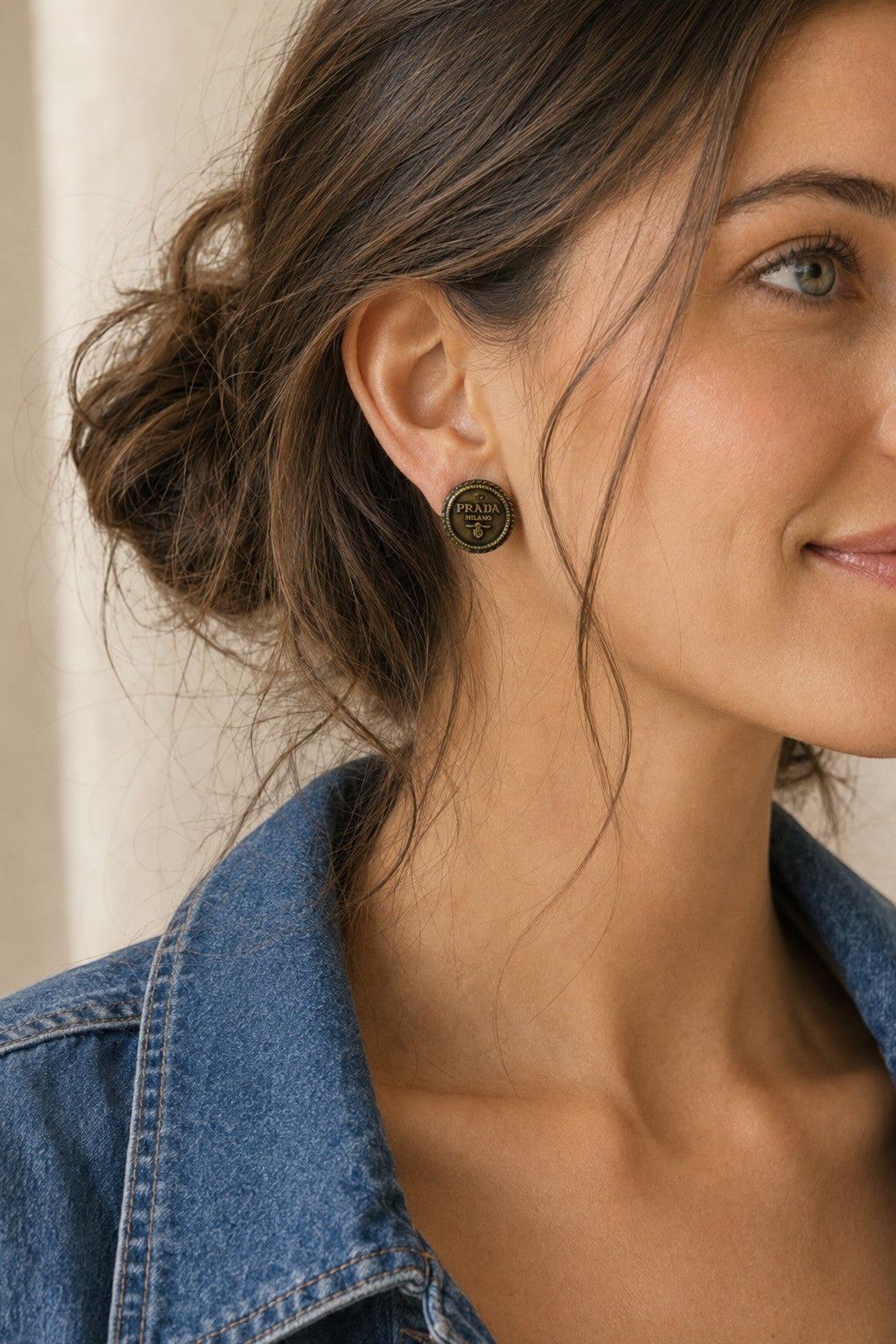 Second Soie handcrafted vintage Prada button earrings in antiqued gold-tone with a rope border worn by a woman.