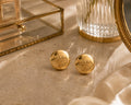 Second Soie vintage Prada Milano gold button earrings with a polished finish on a marble surface.